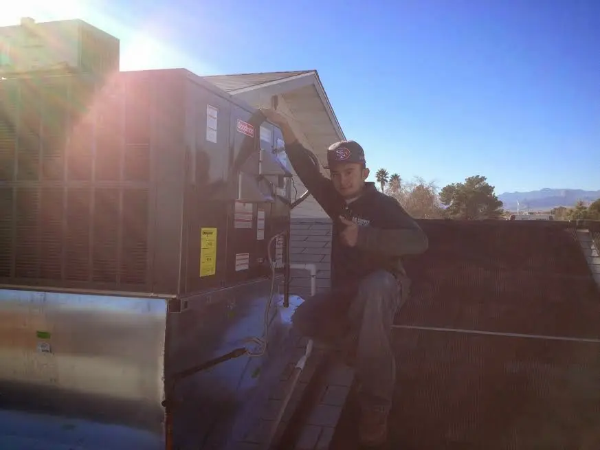 HVAC technician performing Air Duct Cleaning on a rooftop unit in Blythe